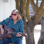 guitar player by tree