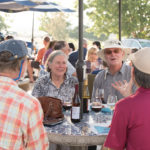 people enjoying wine at table on sunny day